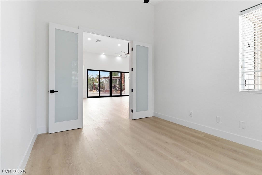 5150 Villa Dante Avenue, Las Vegas, NV 89141 Double glass doors open into an airy office space featuring light wood floors.