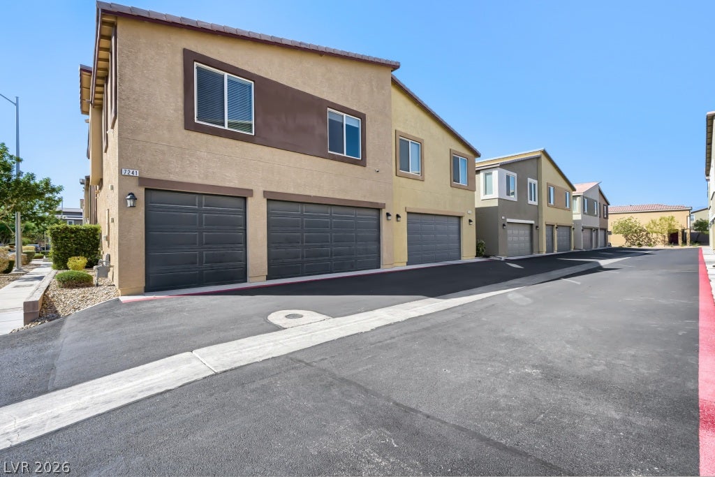 7241 Glistening Star Street, North Las Vegas, NV 89084 Multi-car garage bays line the paved driveway of this modern multi-level exterior.
