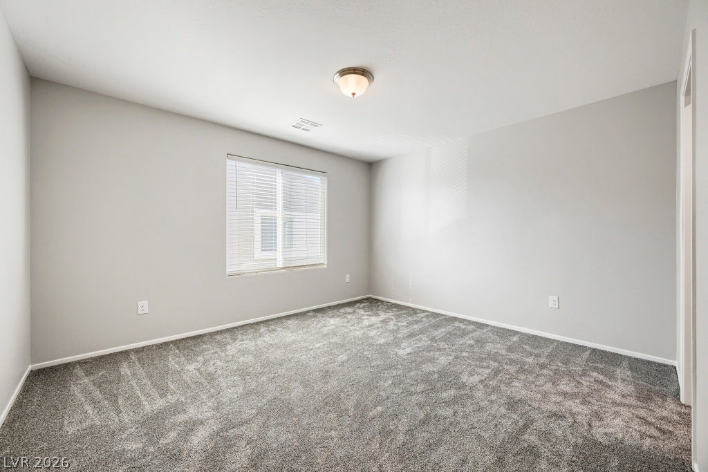7241 Glistening Star Street, North Las Vegas, NV 89084 Plush carpeting anchors this versatile room under a smooth ceiling with central lighting.