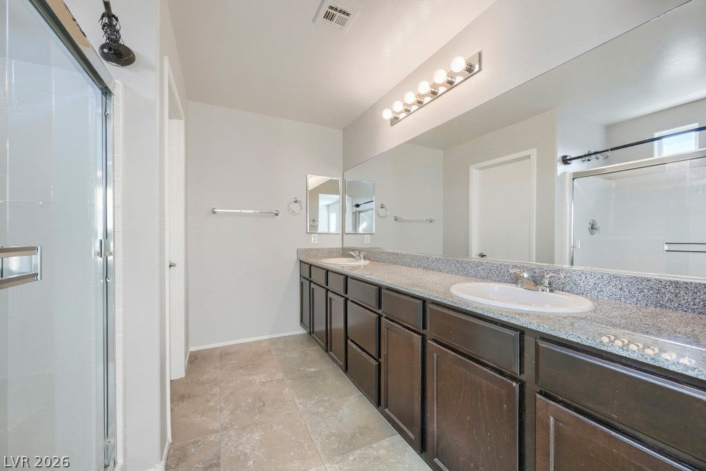 7241 Glistening Star Street, North Las Vegas, NV 89084 A spacious double vanity with granite counters highlights this modern bathroom space.