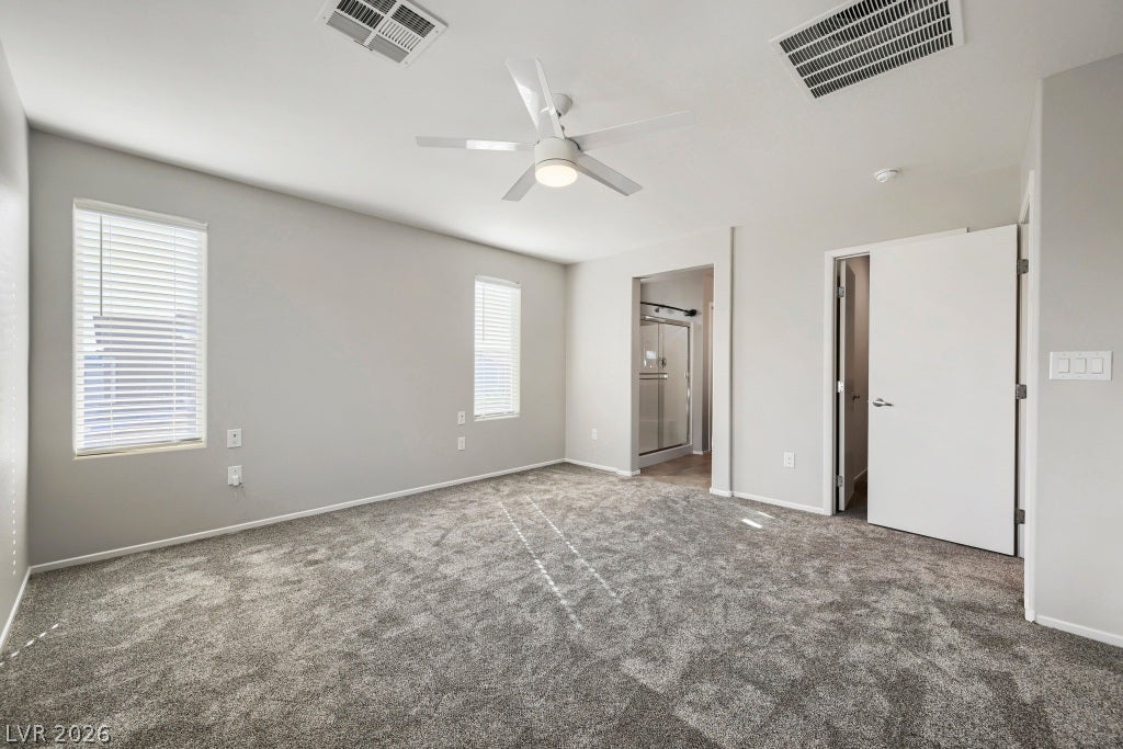 7241 Glistening Star Street, North Las Vegas, NV 89084 Soft carpeting underfoot anchors this spacious bedroom featuring clean lines and dual windows.