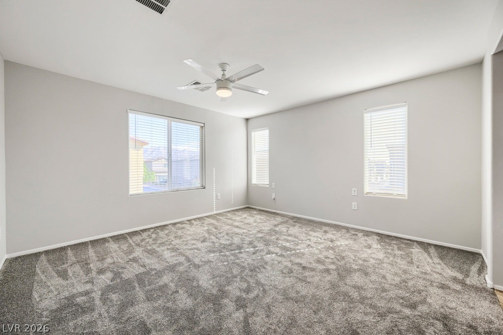 7241 Glistening Star Street, North Las Vegas, NV 89084 Generous window placements invite natural light across the spacious carpeted bedroom floor.