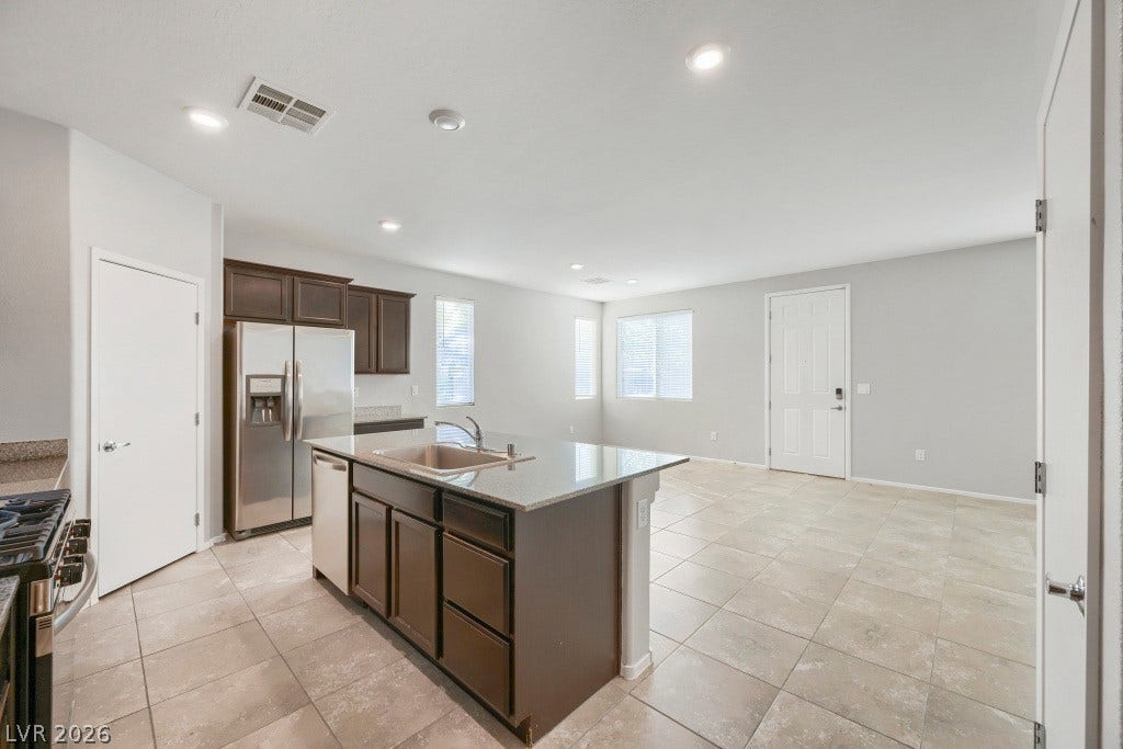 7241 Glistening Star Street, North Las Vegas, NV 89084 An open kitchen with a central island and tile flooring flows into the living area.