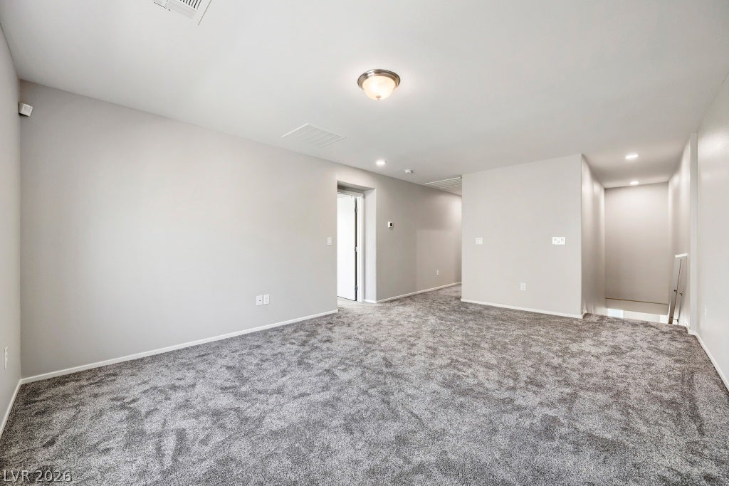7241 Glistening Star Street, North Las Vegas, NV 89084 An open upstairs landing area features neutral plush carpeting and recessed lighting.