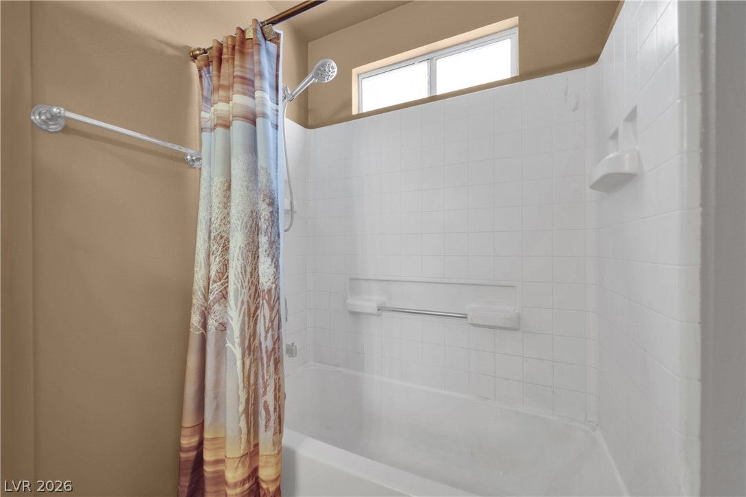 1520 Frank Aved Street, #201, Las Vegas, NV 89110 A classic bathtub and shower combination features clean tiled walls and a high transom window.