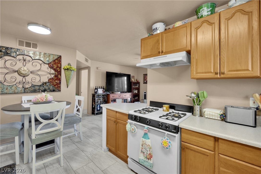 1520 Frank Aved Street, #201, Las Vegas, NV 89110 Classic wooden cabinets and light-colored tile floors define this functional kitchen and dining space.