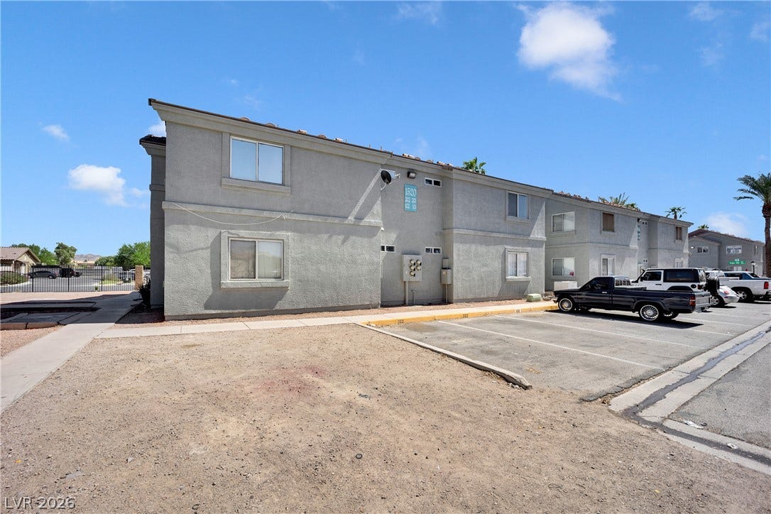 1520 Frank Aved Street, #201, Las Vegas, NV 89110 Multi-family residential building exterior with stucco siding and paved parking stalls.