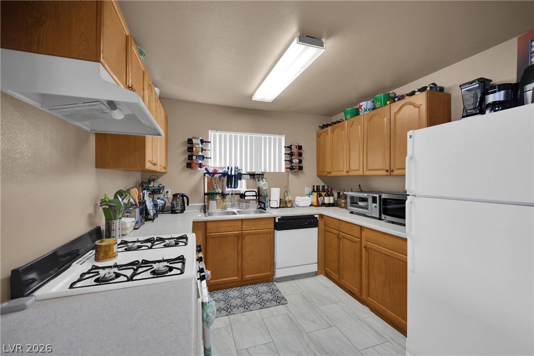 1520 Frank Aved Street, #201, Las Vegas, NV 89110 Warm oak cabinetry pairs with durable tile flooring in this functional U-shaped kitchen layout.