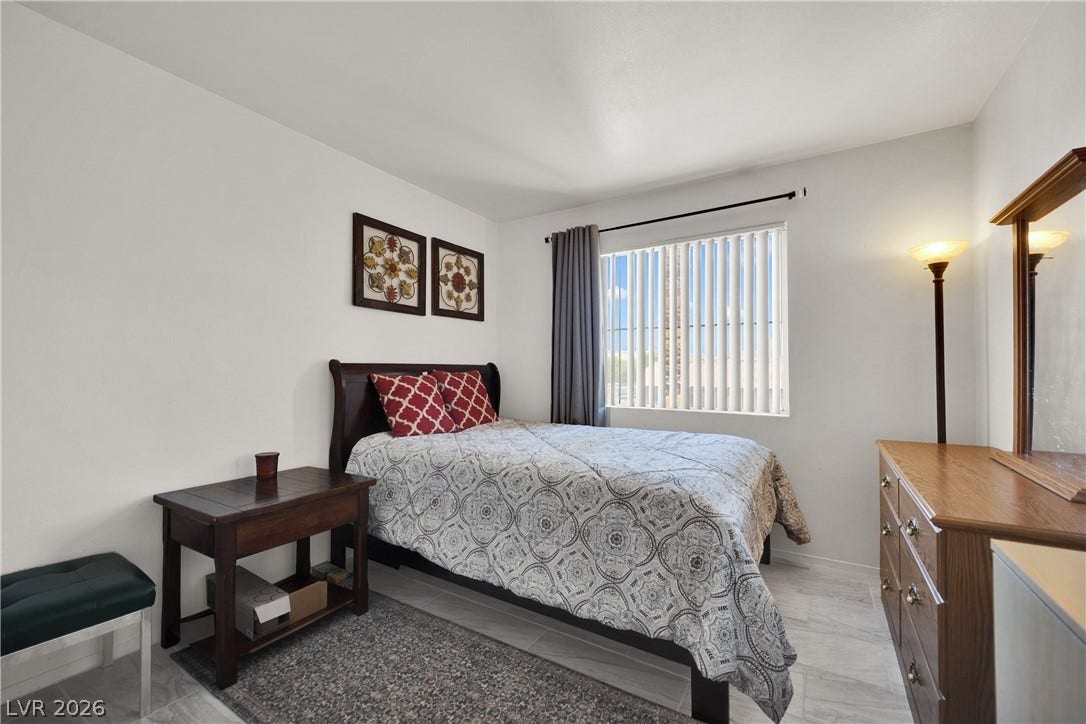 1520 Frank Aved Street, #201, Las Vegas, NV 89110 A window-lit bedroom features tile flooring and smooth plaster walls.