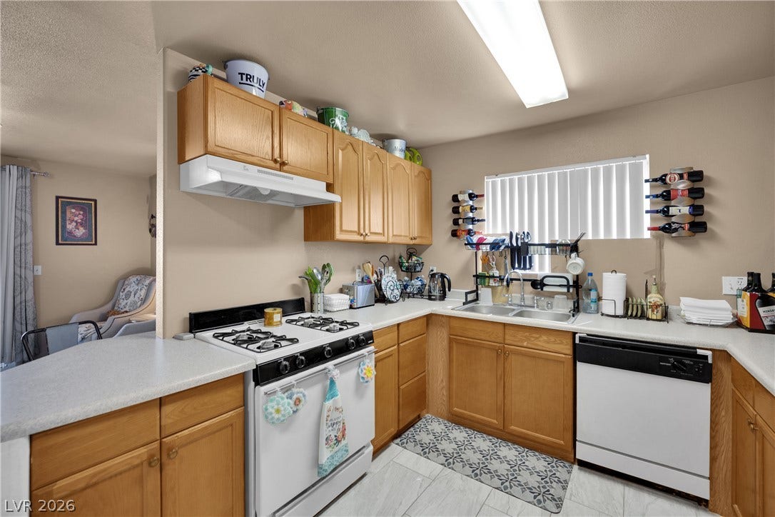 1520 Frank Aved Street, #201, Las Vegas, NV 89110 Oak cabinetry and a practical u-shaped layout define this functional cooking space.