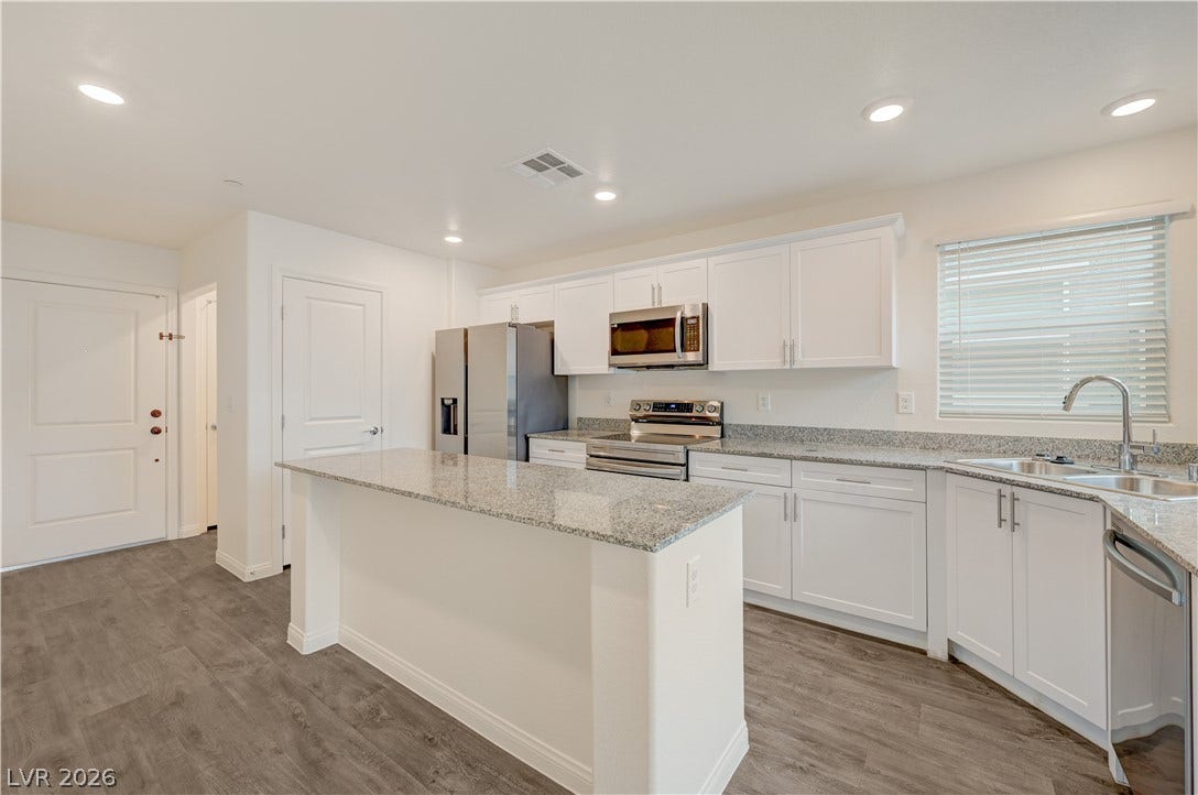 Gleaming stone countertops and a central island anchor this modern culinary space.