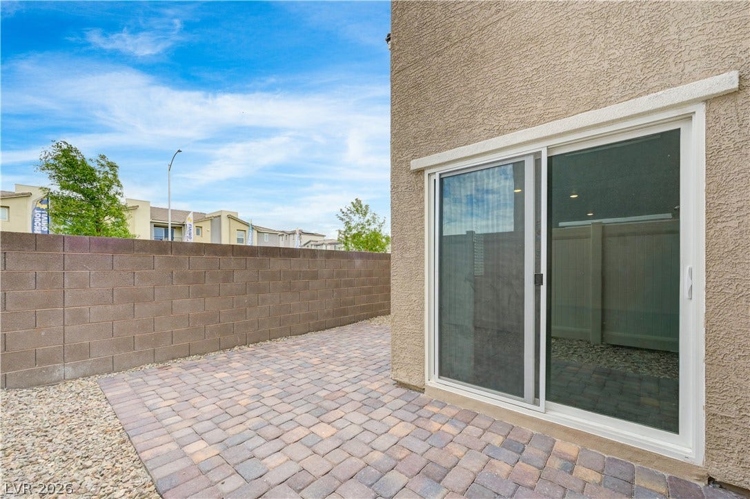 A private paved courtyard provides low-maintenance outdoor living alongside stucco exterior walls.