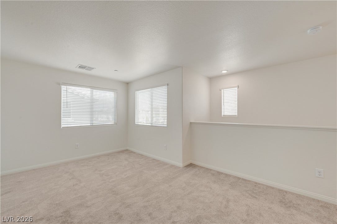 Soft carpeting pairs with crisp walls in this versatile upper-level loft area.