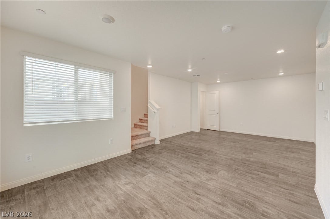 Smooth wood-look flooring and recessed lighting define this versatile open living space.