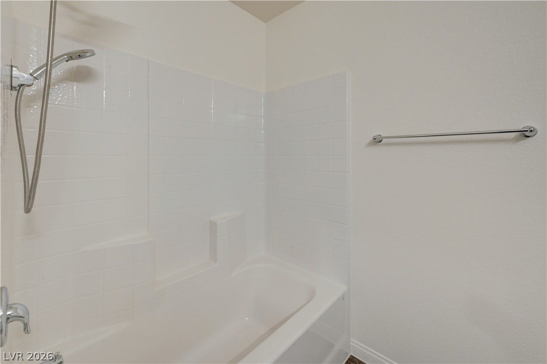 Crisp tiled walls and a deep tub create a serene space for relaxation.