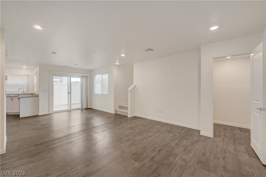 An airy open-concept layout connects the main living spaces over durable wood-look flooring.
