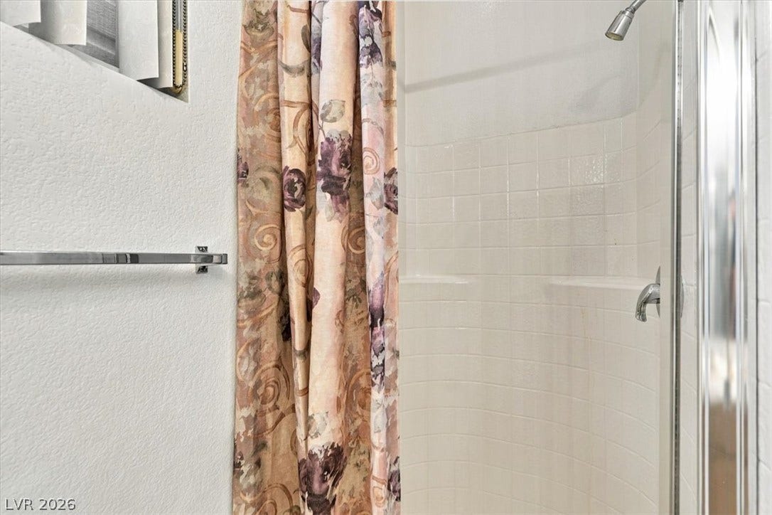 6329 Snow Cactus Street, North Las Vegas, NV 89031 Downstairs-A classic tiled shower stall offers practical design with integrated shelving.
