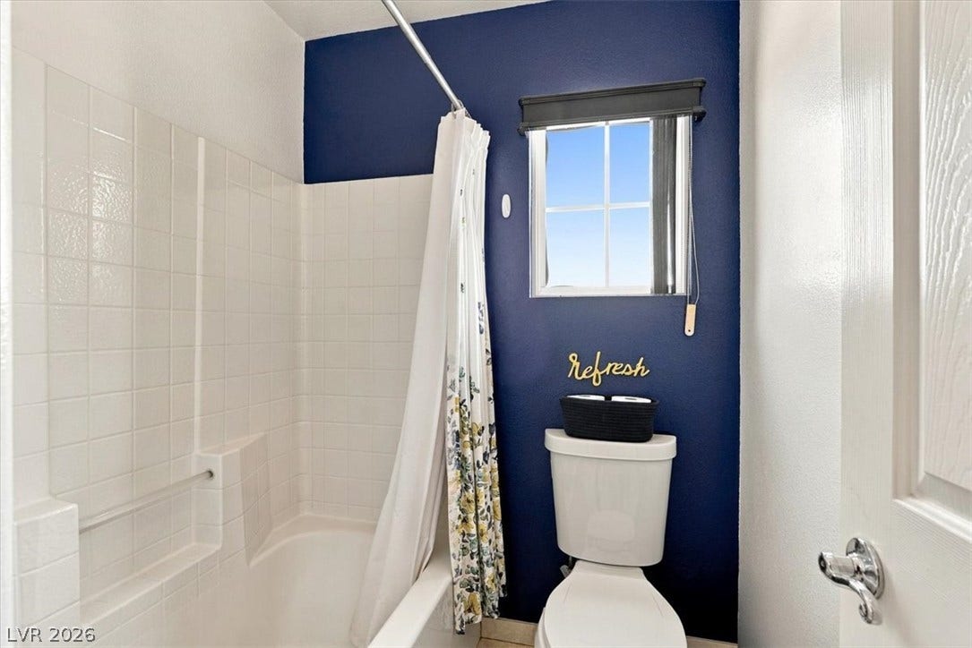 6329 Snow Cactus Street, North Las Vegas, NV 89031 Crisp tiled walls and a bright window elevate this classic bathroom layout.
