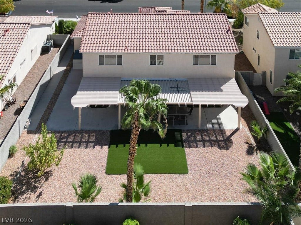 6329 Snow Cactus Street, North Las Vegas, NV 89031 A spacious backyard features low-maintenance gravel landscaping and a covered patio area.