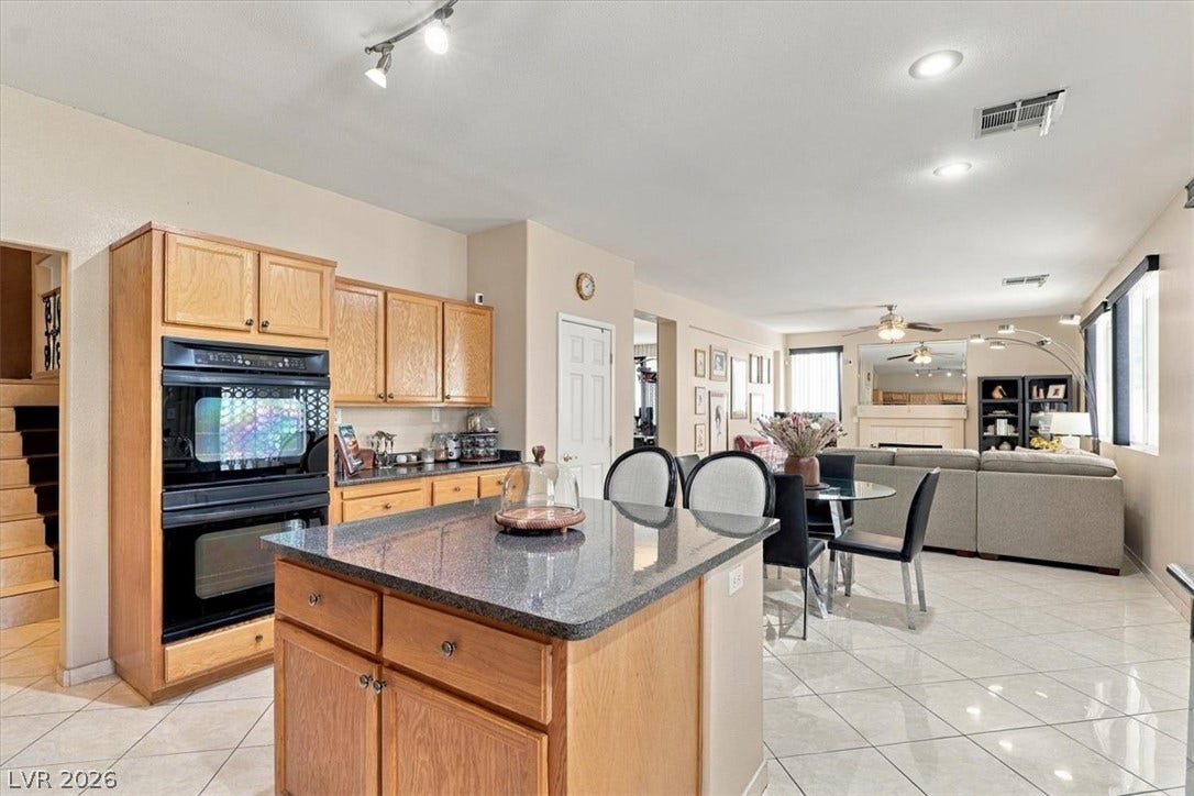 6329 Snow Cactus Street, North Las Vegas, NV 89031 Gleaming tile floors flow from the central kitchen island into the open living space.
