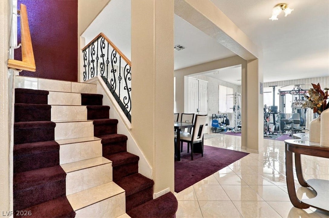 6329 Snow Cactus Street, North Las Vegas, NV 89031 A tiled staircase with a wooden handrail ascends near the open-concept living area.