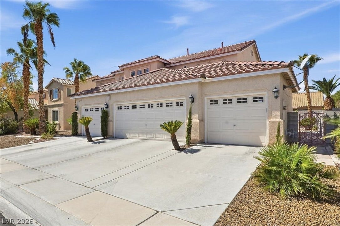 6329 Snow Cactus Street, North Las Vegas, NV 89031 A spacious concrete driveway leads to the multi-car garage of this tile-roofed desert home.