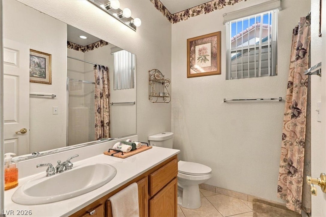 6329 Snow Cactus Street, North Las Vegas, NV 89031 Downstairs-A classic bathroom featuring a wood vanity, light solid-surface countertop, and ceramic tile flooring.