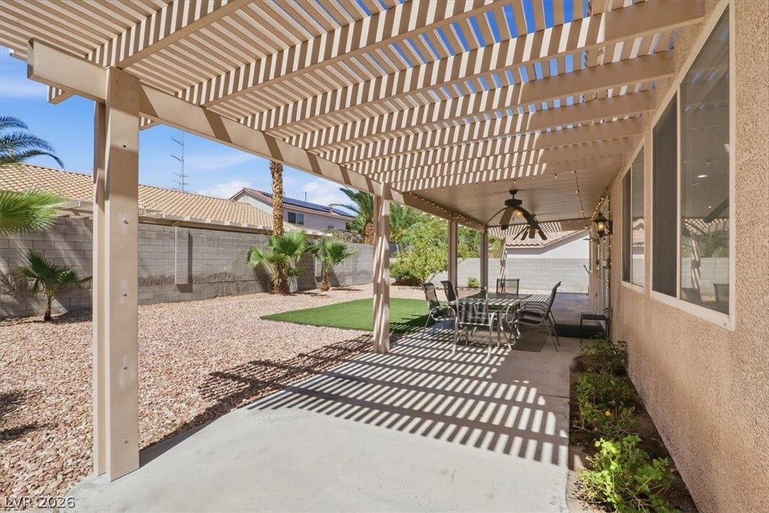 6329 Snow Cactus Street, North Las Vegas, NV 89031 An expansive concrete patio underneath a large shade-providing pergola looks out onto the gravel yard.
