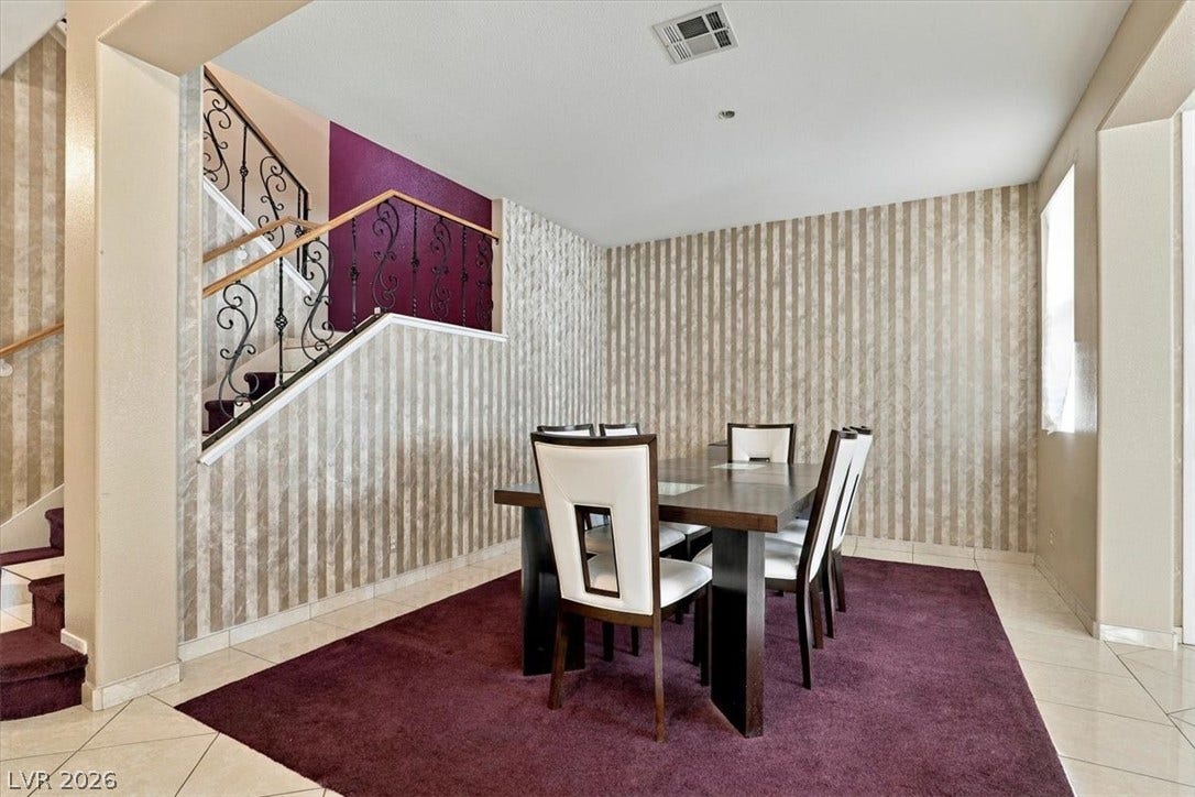 6329 Snow Cactus Street, North Las Vegas, NV 89031 Elegant tile flooring underpins a formal dining area set alongside an ornamental staircase.