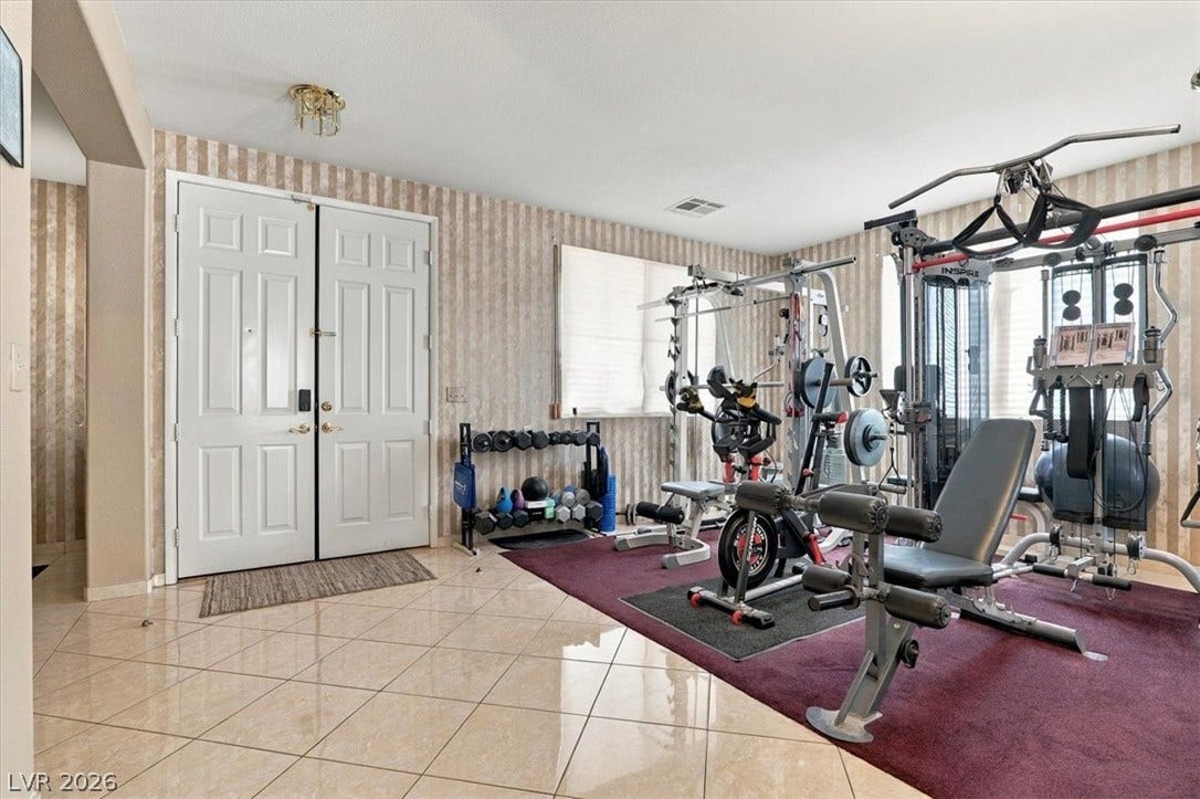 6329 Snow Cactus Street, North Las Vegas, NV 89031 Gleaming tile floors and double doors define this versatile space ideal for a home gym.