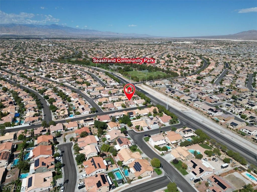 6329 Snow Cactus Street, North Las Vegas, NV 89031 Aerial view showcases a peaceful neighborhood with manicured streets set against a mountain backdrop.