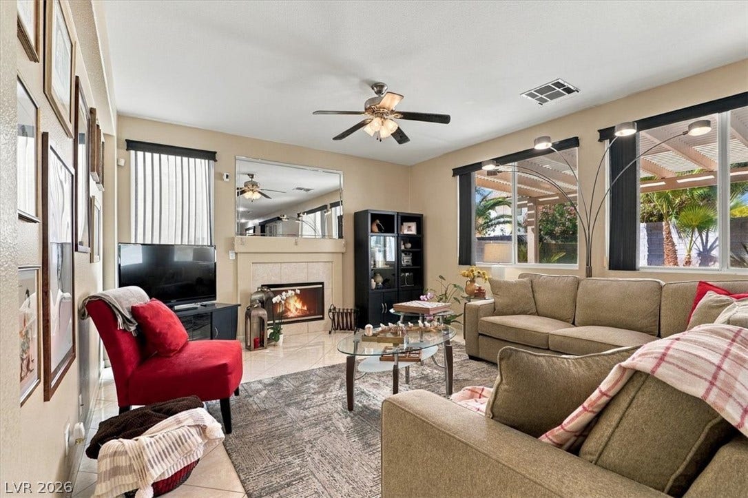 6329 Snow Cactus Street, North Las Vegas, NV 89031 Sunlight streams through large windows into this inviting living area featuring a cozy tile fireplace.