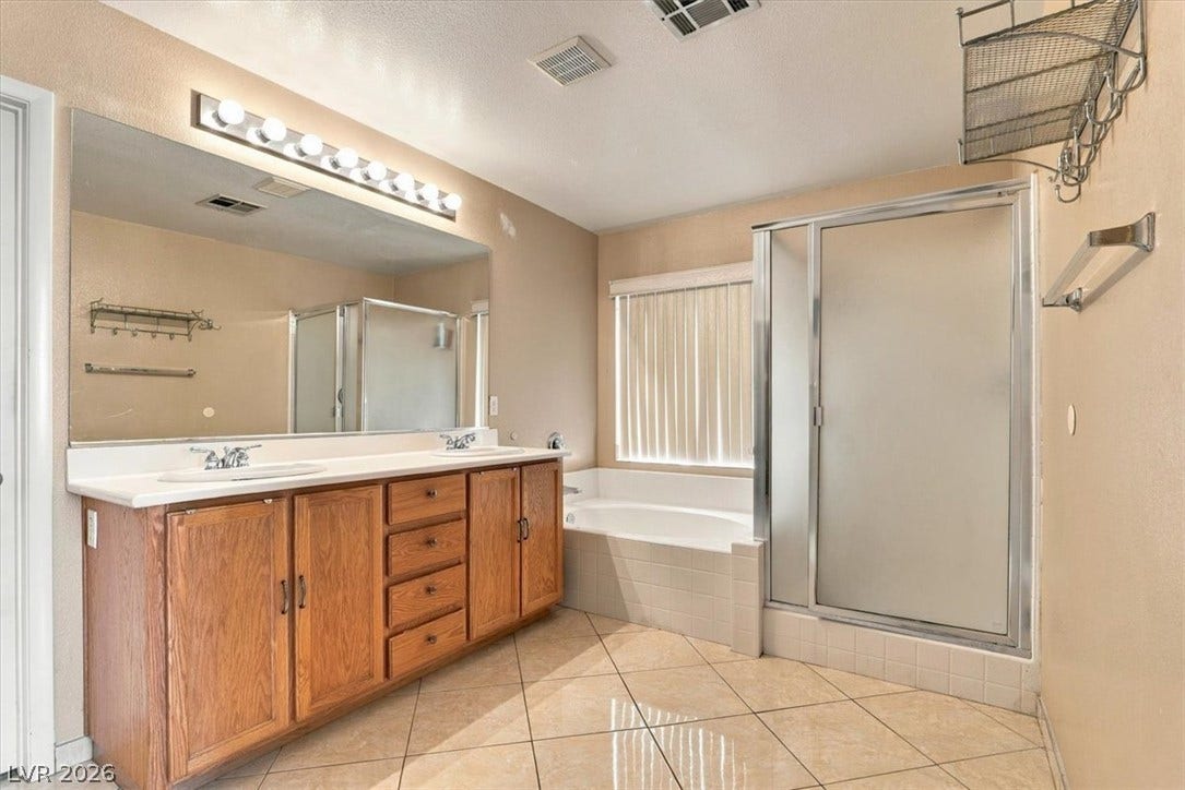 6329 Snow Cactus Street, North Las Vegas, NV 89031 Tiled flooring and a spacious double vanity complement the separate soaking tub and shower enclosure.