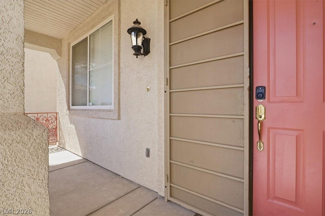 6329 Snow Cactus Street, North Las Vegas, NV 89031 Welcoming front porch features textured stucco walls and secure smart lock entry.