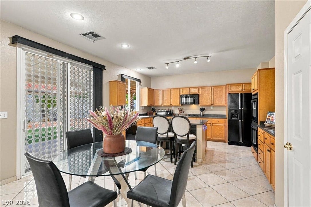6329 Snow Cactus Street, North Las Vegas, NV 89031 Tile flooring and sliding glass doors enhance this open dining area and kitchen.
