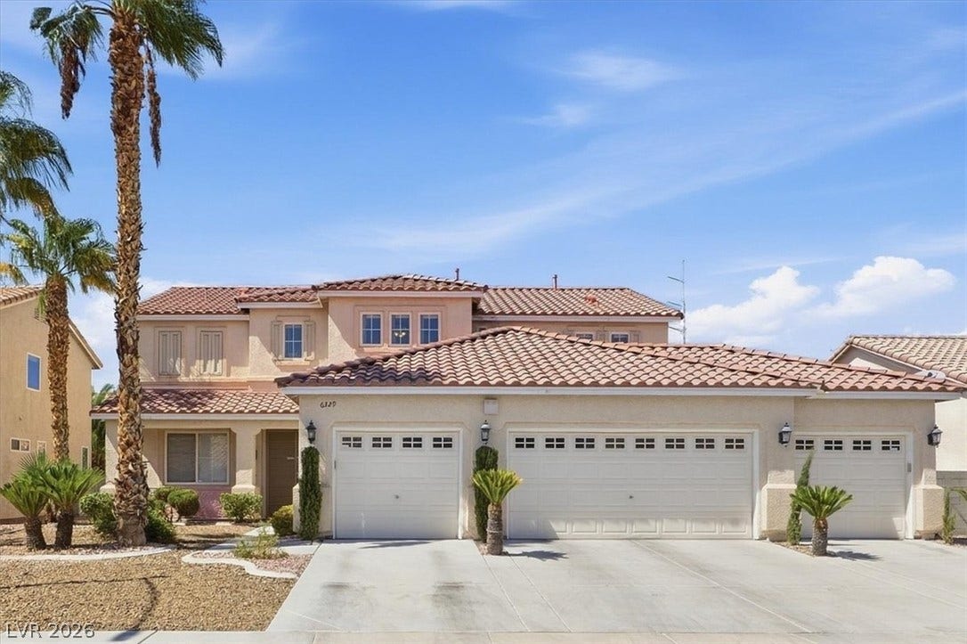 6329 Snow Cactus Street, North Las Vegas, NV 89031 An expansive driveway leads to a multi-car garage beneath a tiled roofline.