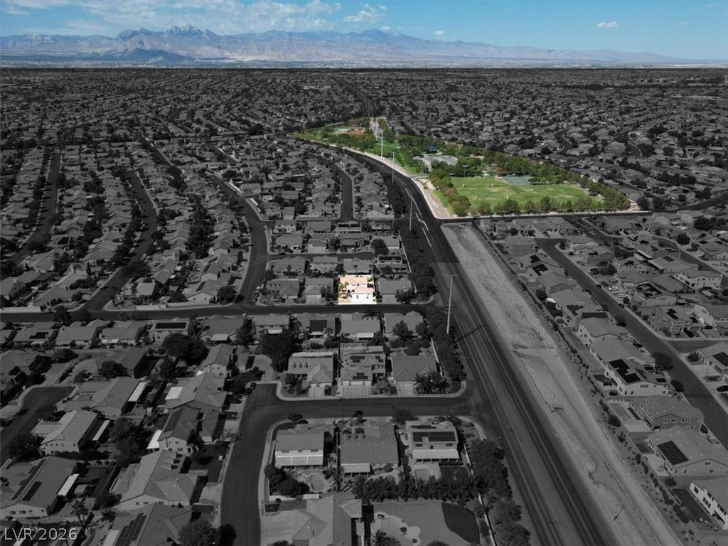 6329 Snow Cactus Street, North Las Vegas, NV 89031 An aerial perspective showcases the neighborhood layout with majestic mountains framing the distant horizon.