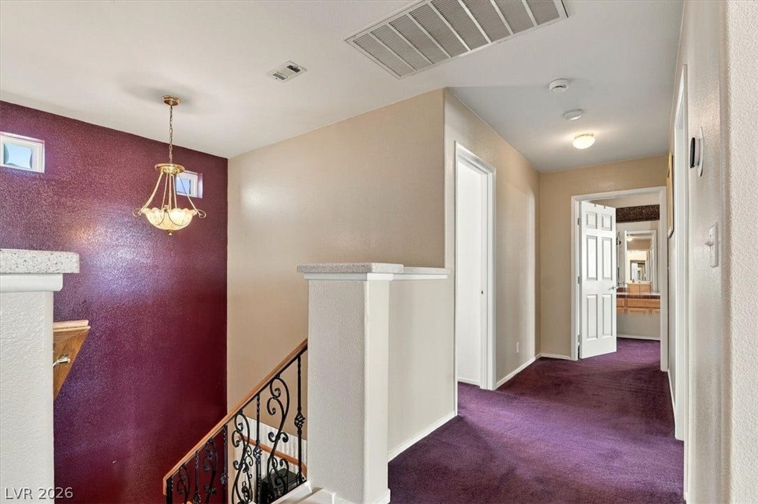 6329 Snow Cactus Street, North Las Vegas, NV 89031 A spacious upper landing connects light-filled hallways and stairs with decorative iron railings.