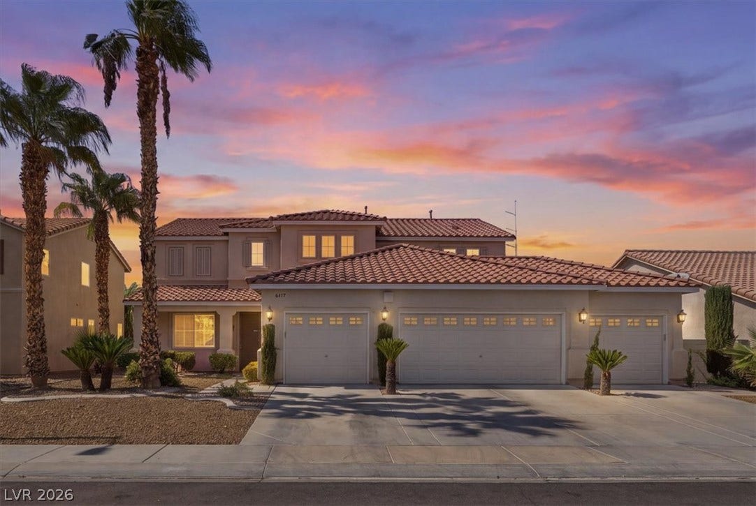 6329 Snow Cactus Street, North Las Vegas, NV 89031 A spacious driveway and multiple garage bays frame this tile-roofed residence beneath desert twilight.