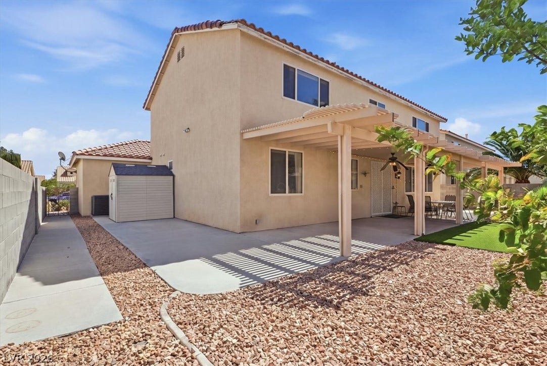 6329 Snow Cactus Street, North Las Vegas, NV 89031 A spacious concrete patio rests beneath a large wood pergola in the private backyard.