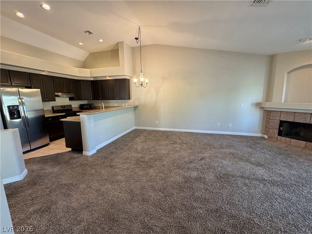 Plush carpeting and a cozy fireplace define this open main-level living space.