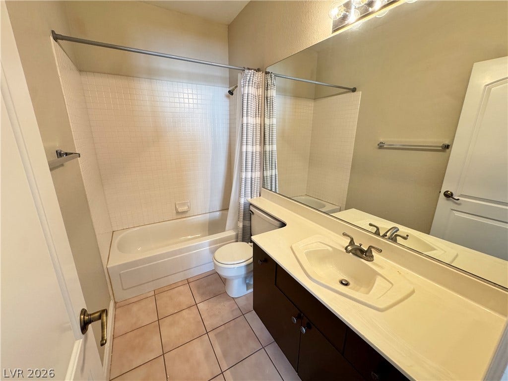 Tiled flooring and a spacious vanity complete this classic full bath layout.