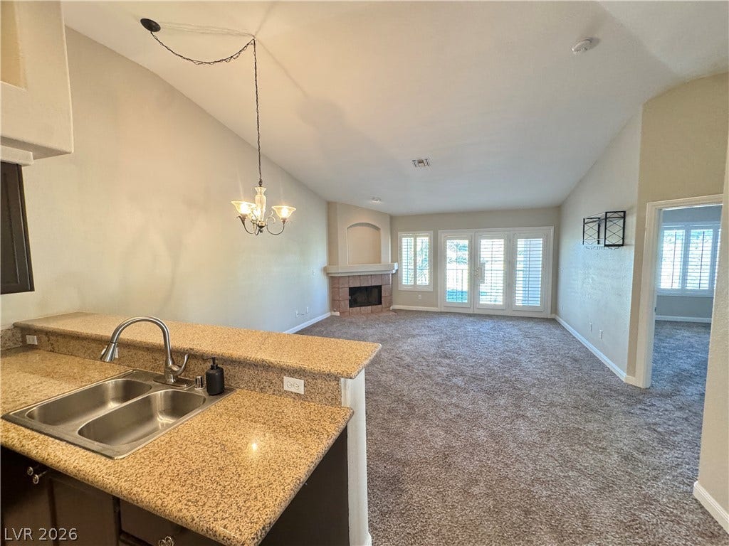 Vaulted ceilings and a corner fireplace anchor this open living area.