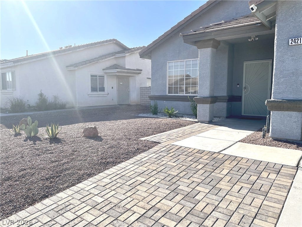2421 Sunrise Springs Court, North Las Vegas, NV 89031 An inviting paver stone pathway leads to the covered front entrance of this modern home.