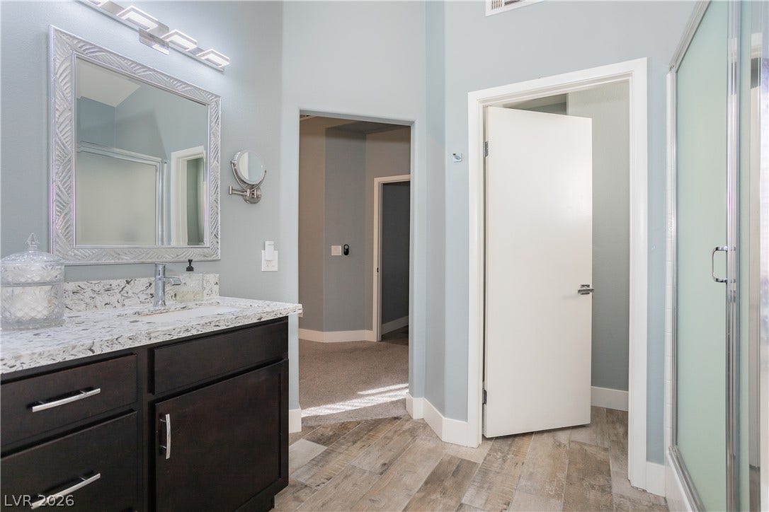 2421 Sunrise Springs Court, North Las Vegas, NV 89031 High ceilings and wood-look tile flooring elevate this modern bath space.