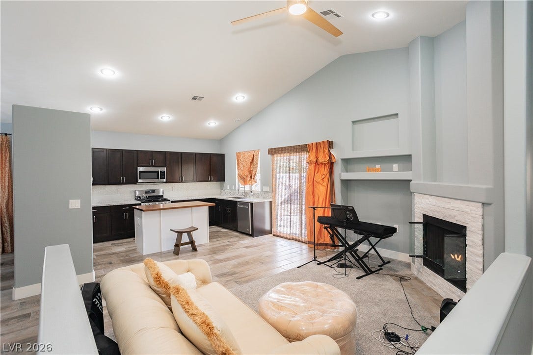 2421 Sunrise Springs Court, North Las Vegas, NV 89031 Vaulted ceilings and a stone fireplace define this inviting, open-concept living space.