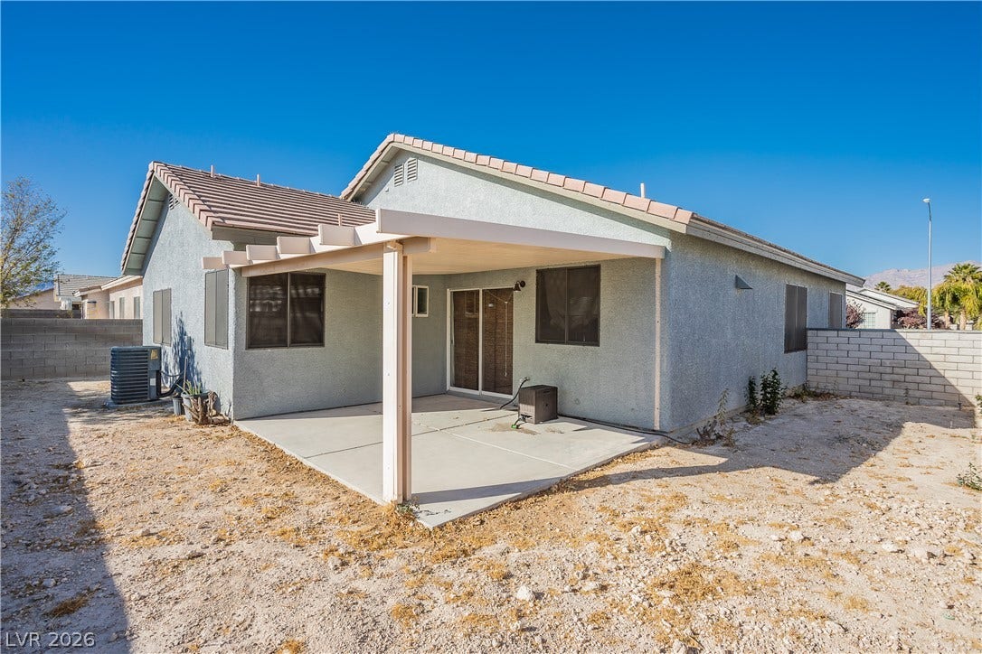 2421 Sunrise Springs Court, North Las Vegas, NV 89031 A covered concrete patio extends from the stucco exterior under clear desert skies.