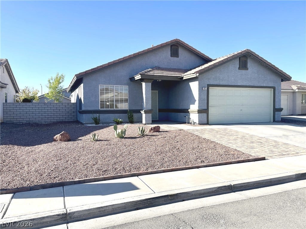 2421 Sunrise Springs Court, North Las Vegas, NV 89031 An inviting stucco exterior stands out against a tidy low-maintenance desert front yard.