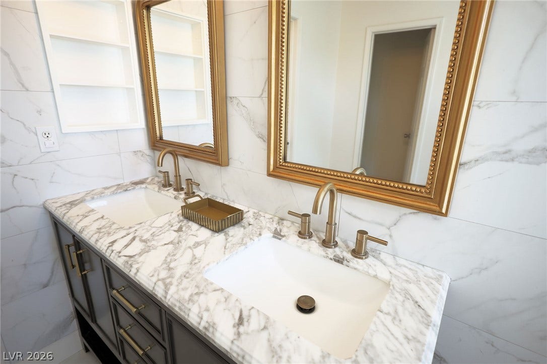 3018 Via Sarafina Drive, Henderson, NV 89052 Elegance defines this space featuring a dual vanity, marble countertops, and ornate gold-framed mirrors.