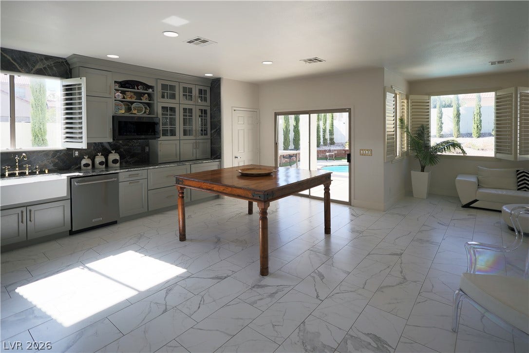 3018 Via Sarafina Drive, Henderson, NV 89052 Gleaming stone tile flooring and custom cabinetry define this open kitchen design.